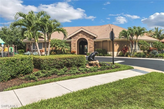 7327 Acorn Way, Naples, FL 34119 - ranch-style home featuring stone siding, a tiled roof, stucco siding, and a playground