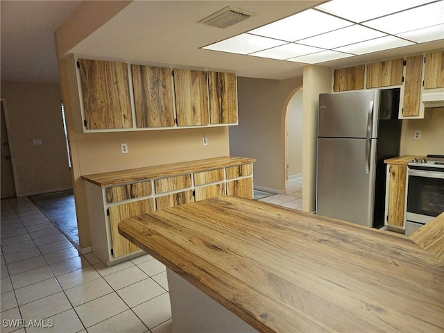 3616 SW 1st Pl, Cape Coral, FL 33914 - kitchen featuring appliances with stainless steel finishes, arched walkways, light tile patterned floors, and wood counters