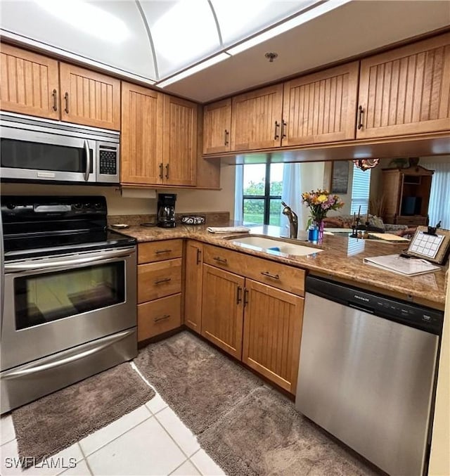 16750 Bocilla Palms Dr Unit 74, Bokeelia, FL 33922 - kitchen featuring stainless steel appliances, tile patterned flooring, a peninsula, and brown cabinets