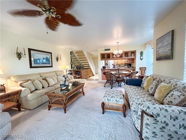 16750 Bocilla Palms Dr Unit 74, Bokeelia, FL 33922 - living room featuring stairway, light carpet, a chandelier, and a ceiling fan