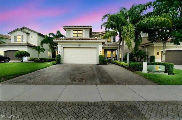 4119 Zelkova Ct, Naples, FL 34119 - mediterranean / spanish-style home featuring decorative driveway, stucco siding, a tile roof, a lawn, and an attached garage