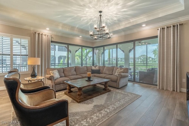 16375 Viansa Way Unit 102, Naples, FL 34110 - living room featuring plenty of natural light, a chandelier, wood finished floors, ornamental molding, and a raised ceiling