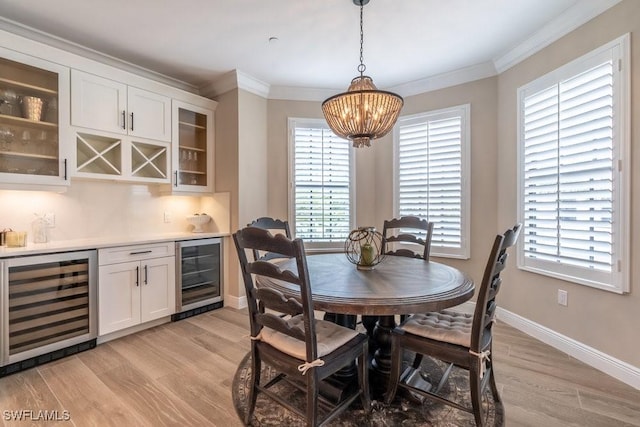 16375 Viansa Way Unit 102, Naples, FL 34110 - dining area featuring beverage cooler, light wood-type flooring, bar area, a chandelier, and ornamental molding