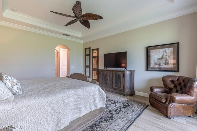 16375 Viansa Way Unit 102, Naples, FL 34110 - bedroom featuring a raised ceiling, arched walkways, ornamental molding, wood finished floors, and a ceiling fan