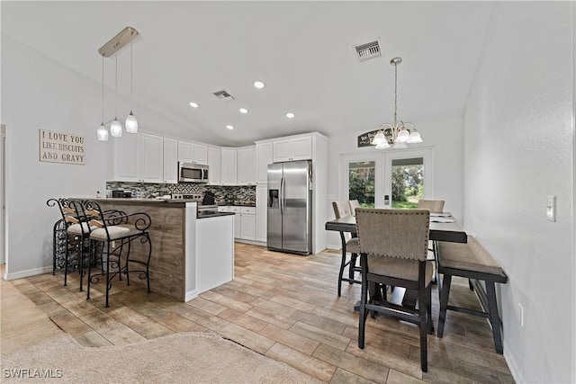 1429 Jabara Cir, Labelle, FL 33935 - kitchen featuring stainless steel appliances, backsplash, a peninsula, white cabinetry, and a chandelier
