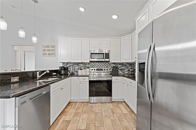 1429 Jabara Cir, Labelle, FL 33935 - kitchen featuring appliances with stainless steel finishes, a peninsula, white cabinetry, light wood-type flooring, and tasteful backsplash