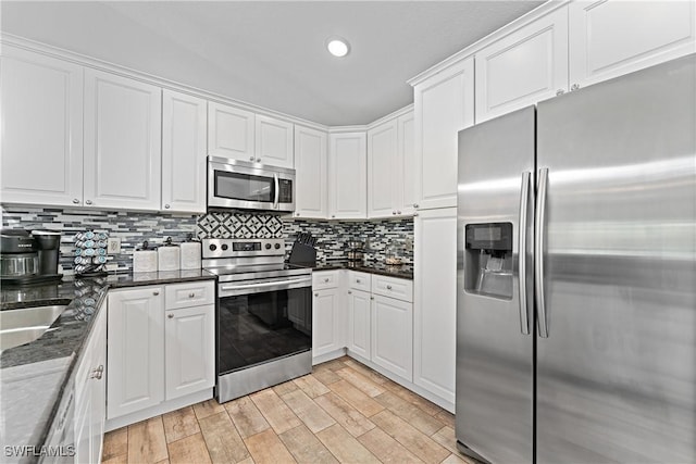 1429 Jabara Cir, Labelle, FL 33935 - kitchen featuring stainless steel appliances, white cabinetry, tasteful backsplash, light wood-type flooring, and recessed lighting