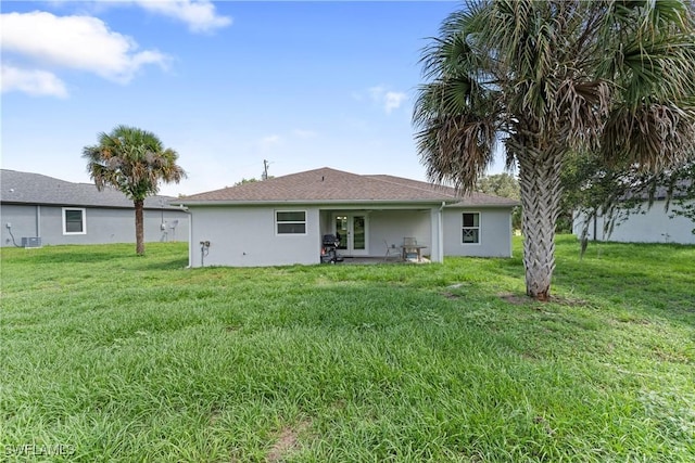 1429 Jabara Cir, Labelle, FL 33935 - rear view of house with stucco siding, a yard, and french doors