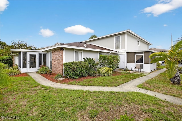 3291 Royal Canadian Trce Unit 3, Fort Myers, FL 33907 - rear view of property featuring a sunroom, a lawn, and stucco siding