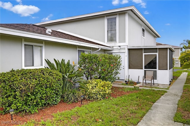 3291 Royal Canadian Trce Unit 3, Fort Myers, FL 33907 - view of property exterior with a sunroom, stucco siding, and roof with shingles