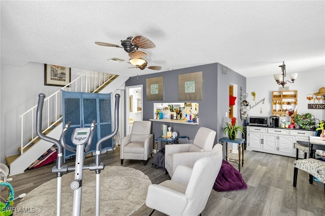 3291 Royal Canadian Trce Unit 3, Fort Myers, FL 33907 - living area featuring stairway, wood finished floors, ceiling fan, a textured ceiling, and a chandelier