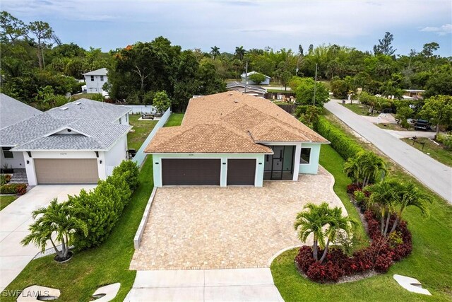 10295 Carolina St, Bonita Springs, FL 34135 - view of front facade featuring decorative driveway, an attached garage, stucco siding, and a front yard