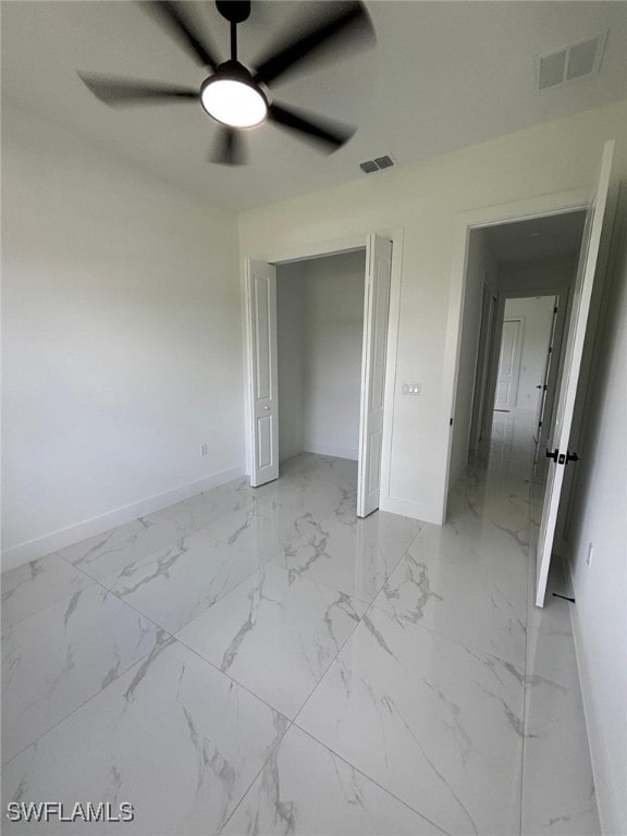 2909 Dora Ave N, Lehigh Acres, FL 33971 - unfurnished bedroom featuring light marble finish flooring, a closet, and a ceiling fan