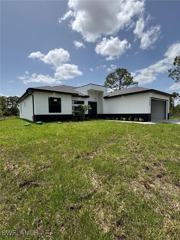 2909 Dora Ave N, Lehigh Acres, FL 33971 - view of front of home with a front yard, a garage, and stucco siding