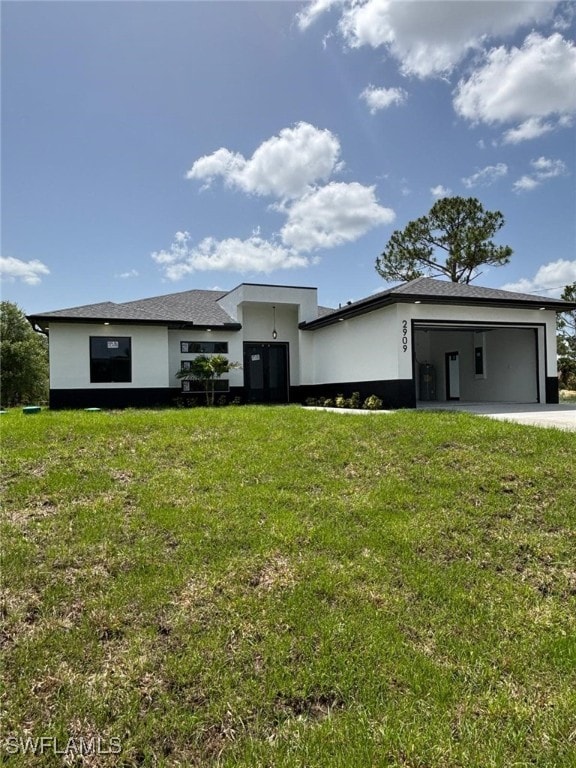 2909 Dora Ave N, Lehigh Acres, FL 33971 - view of front of property with stucco siding, a garage, and a front yard