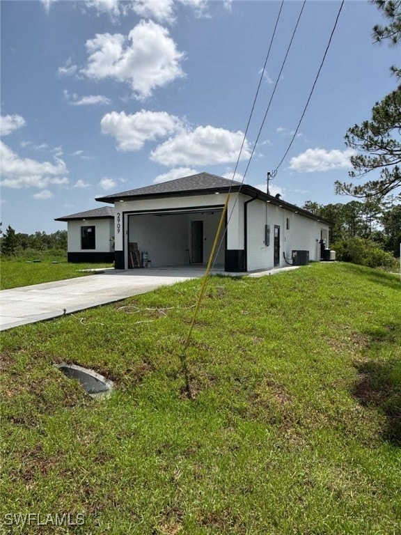 2909 Dora Ave N, Lehigh Acres, FL 33971 - view of front of home with concrete driveway, a front lawn, stucco siding, and an attached garage