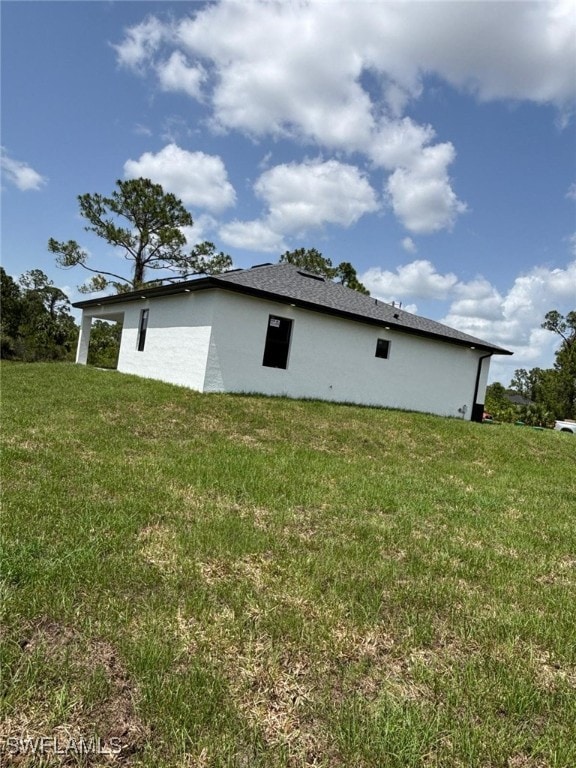 2909 Dora Ave N, Lehigh Acres, FL 33971 - view of home's exterior featuring a lawn and stucco siding