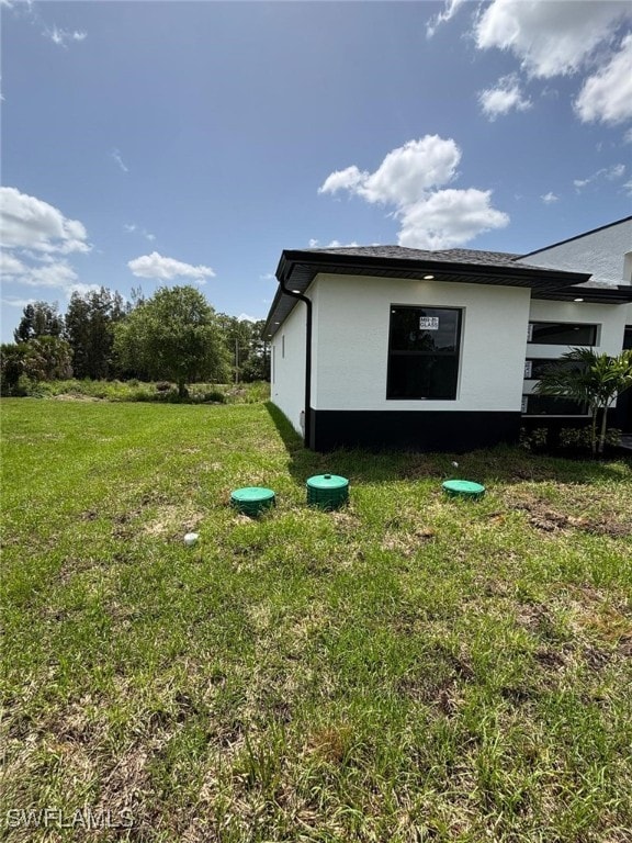 2909 Dora Ave N, Lehigh Acres, FL 33971 - view of home's exterior with stucco siding and a lawn
