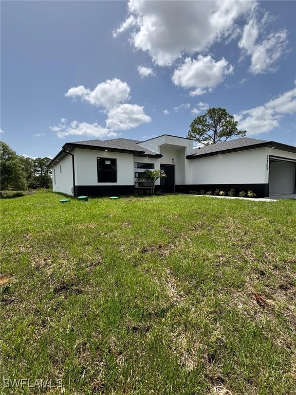 2909 Dora Ave N, Lehigh Acres, FL 33971 - view of front of house featuring a front yard and stucco siding