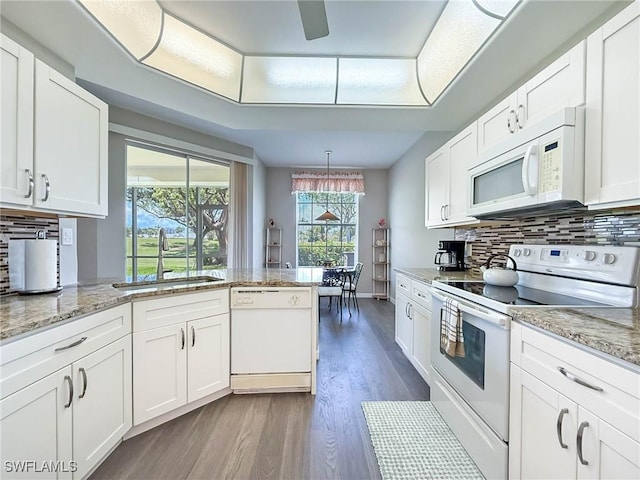 15054 Tamarind Cay Ct Unit 706, Fort Myers, FL 33908 - kitchen with white appliances, dark wood-type flooring, white cabinets, backsplash, and a peninsula