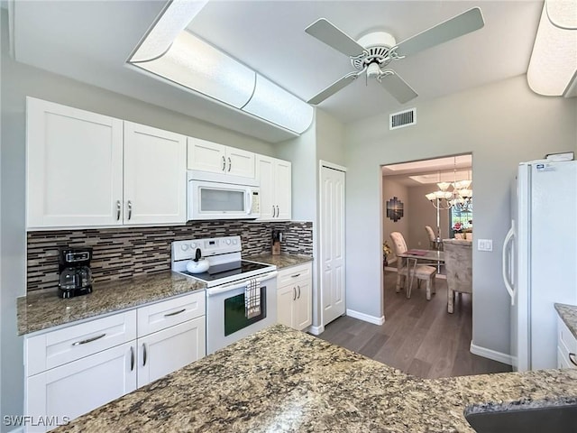 15054 Tamarind Cay Ct Unit 706, Fort Myers, FL 33908 - kitchen with white appliances, dark wood-type flooring, decorative backsplash, white cabinetry, and dark stone counters