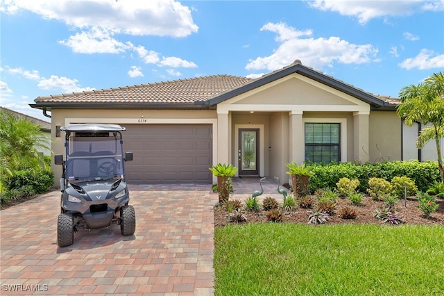 6334 Achievement Ave, Ave Maria, FL 34142 - view of front facade with stucco siding, a tiled roof, and an attached garage