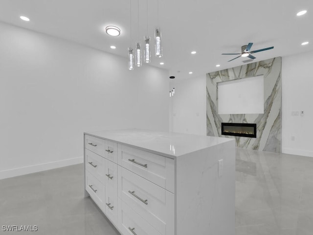 3301 8th St SW, Lehigh Acres, FL 33976 - kitchen featuring recessed lighting, white cabinets, a high end fireplace, a ceiling fan, and a kitchen island