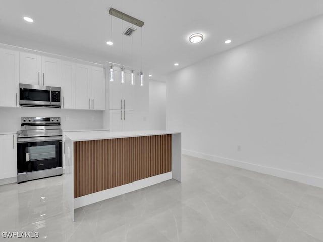3301 8th St SW, Lehigh Acres, FL 33976 - kitchen with appliances with stainless steel finishes, light countertops, white cabinets, recessed lighting, and a center island