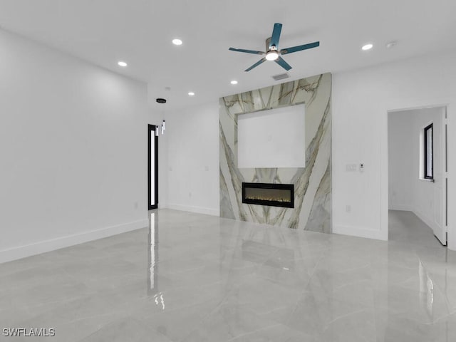 3301 8th St SW, Lehigh Acres, FL 33976 - unfurnished living room with recessed lighting, a ceiling fan, marble finish flooring, a fireplace, and baseboards