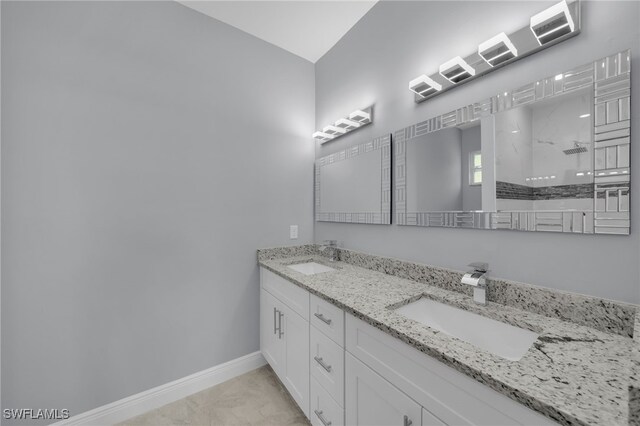 908 Barcia St E, Lehigh Acres, FL 33974 - bathroom with double vanity, baseboards, marble look tile flooring, and walk in shower