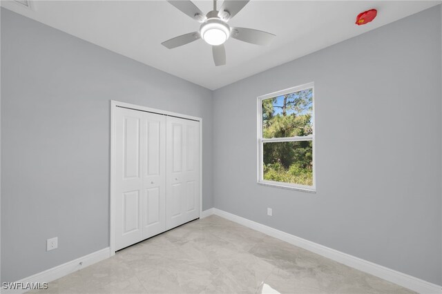 908 Barcia St E, Lehigh Acres, FL 33974 - unfurnished bedroom with baseboards, a closet, a ceiling fan, and light marble finish floors