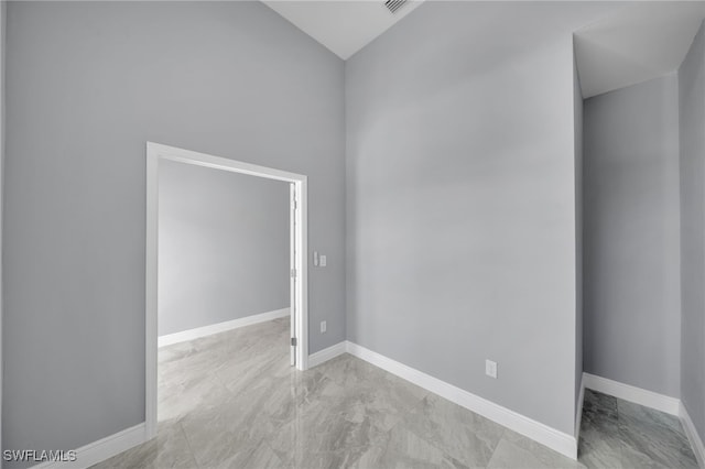 908 Barcia St E, Lehigh Acres, FL 33974 - spare room with lofted ceiling and baseboards