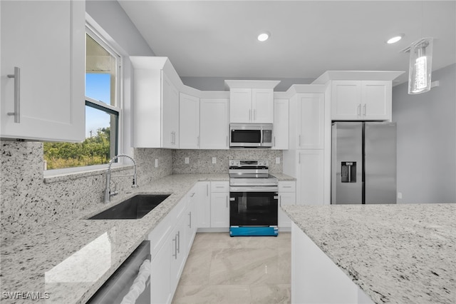 908 Barcia St E, Lehigh Acres, FL 33974 - kitchen featuring appliances with stainless steel finishes, a sink, white cabinets, light stone counters, and recessed lighting