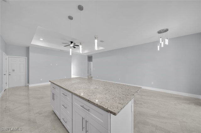 908 Barcia St E, Lehigh Acres, FL 33974 - kitchen featuring a center island, open floor plan, pendant lighting, a ceiling fan, and white cabinetry