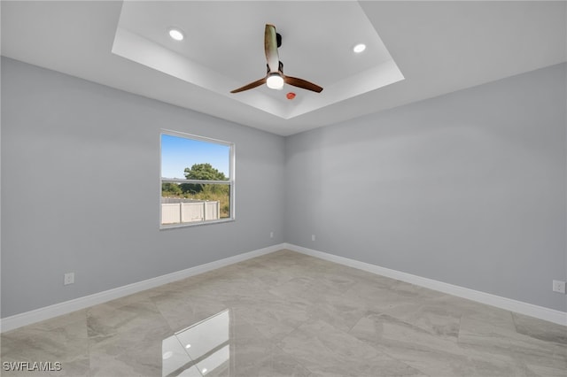 908 Barcia St E, Lehigh Acres, FL 33974 - spare room with a ceiling fan, a tray ceiling, baseboards, and recessed lighting