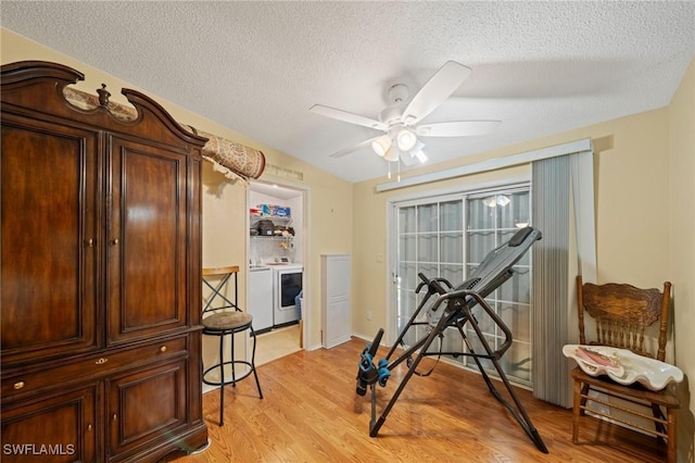 919 Manatee Rd, Naples, FL 34114 - workout room with light wood-type flooring, ceiling fan, a textured ceiling, and washing machine and dryer