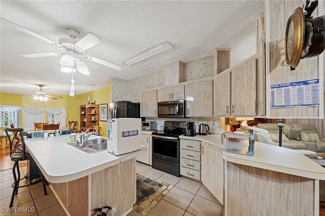 919 Manatee Rd, Naples, FL 34114 - kitchen with appliances with stainless steel finishes, light tile patterned flooring, light brown cabinets, a kitchen breakfast bar, and a textured ceiling