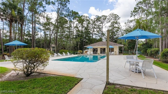 3451 County Barn Rd Unit G103, Naples, FL 34112 - community pool with a patio, a storage structure, an outbuilding, and view of wooded area