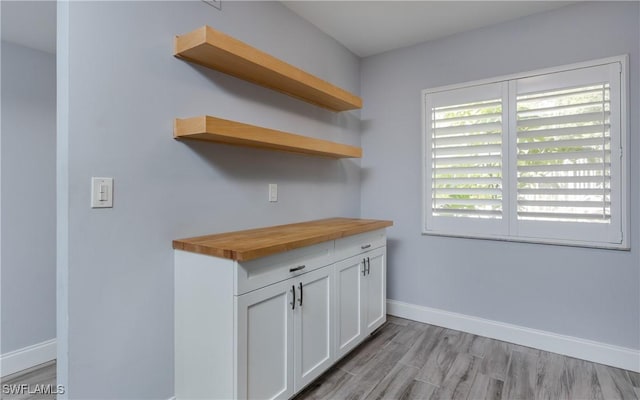 3451 County Barn Rd Unit G103, Naples, FL 34112 - interior space featuring wood counters, light wood-style floors, white cabinets, and open shelves