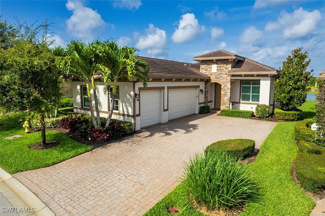 2977 Willow Ridge Ct, Fort Myers, FL 33905 - mediterranean / spanish house with an attached garage, stucco siding, decorative driveway, stone siding, and a tile roof