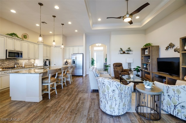 2977 Willow Ridge Ct, Fort Myers, FL 33905 - living room featuring a tray ceiling, ornamental molding, ceiling fan, dark wood finished floors, and arched walkways