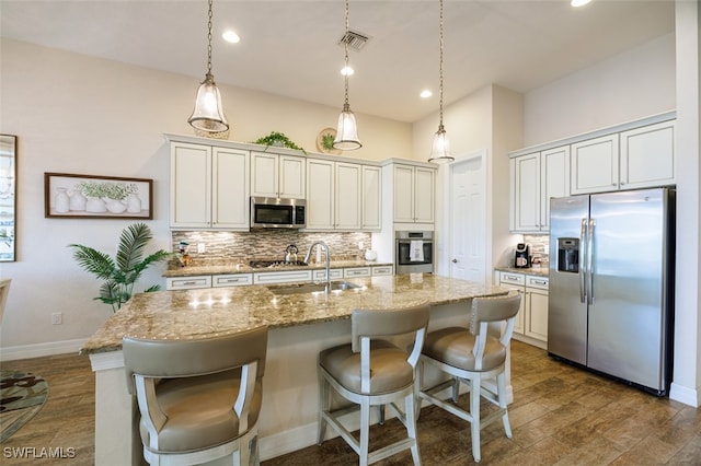 2977 Willow Ridge Ct, Fort Myers, FL 33905 - kitchen with appliances with stainless steel finishes, backsplash, dark wood finished floors, a center island with sink, and light stone countertops
