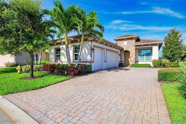 2977 Willow Ridge Ct, Fort Myers, FL 33905 - view of front of property featuring an attached garage, stucco siding, decorative driveway, stone siding, and a front yard