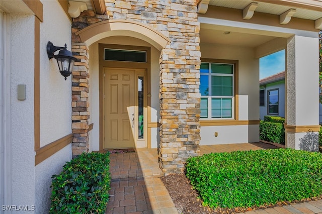 2977 Willow Ridge Ct, Fort Myers, FL 33905 - view of exterior entry featuring stone siding, stucco siding, and a porch