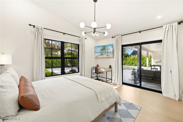7658 Ponte Verde Way, Naples, FL 34109 - bedroom featuring multiple windows, access to outside, wood finished floors, lofted ceiling, and a chandelier