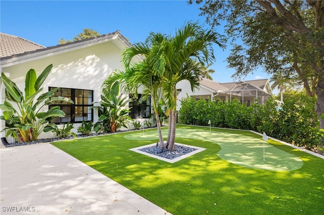 7658 Ponte Verde Way, Naples, FL 34109 - view of yard featuring a putting green and glass enclosure