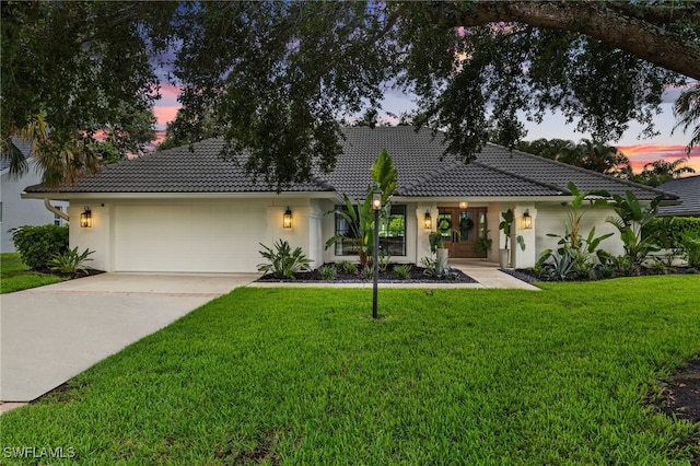 7658 Ponte Verde Way, Naples, FL 34109 - view of front of home featuring a garage, driveway, a tiled roof, and stucco siding