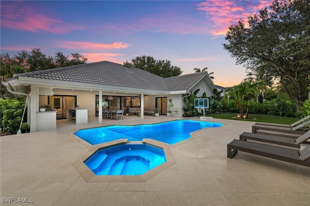 7658 Ponte Verde Way, Naples, FL 34109 - pool at dusk with a patio area, an outdoor hangout area, and a pool with connected hot tub