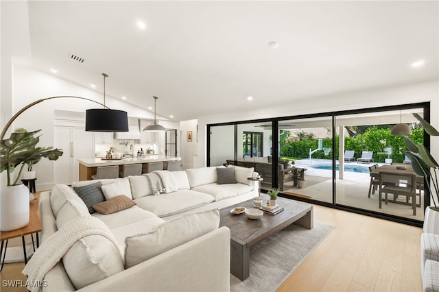 7658 Ponte Verde Way, Naples, FL 34109 - living room featuring lofted ceiling, recessed lighting, and light wood-style flooring