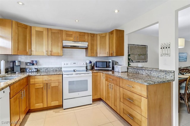1100 8th Ave S Unit 211B, Naples, FL 34102 - kitchen featuring white appliances, under cabinet range hood, tasteful backsplash, light stone counters, and recessed lighting